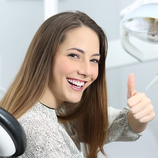 Étudiante souriante faisant un pouce levé
